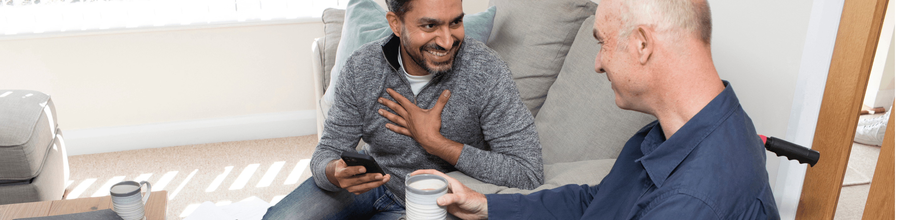 Support worker and client with wheelchair chatting together at home in Nottingham