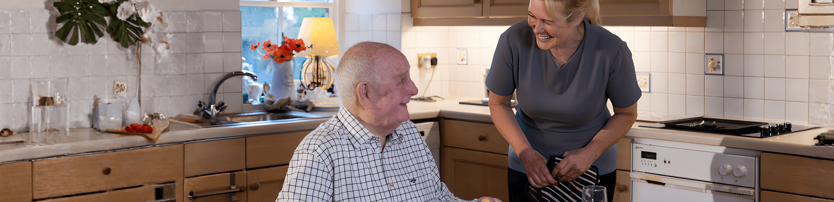 Home carer helping elderly man with a meal in his kitchen in Nottingham