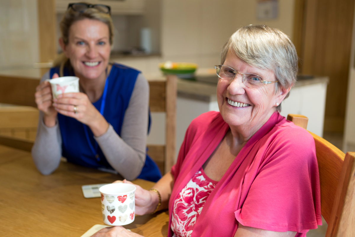 Carer and elderly woman sharing tea and conversation at home in Nottingham A regular friendly face can make an enormous difference. Companionship is care too.
